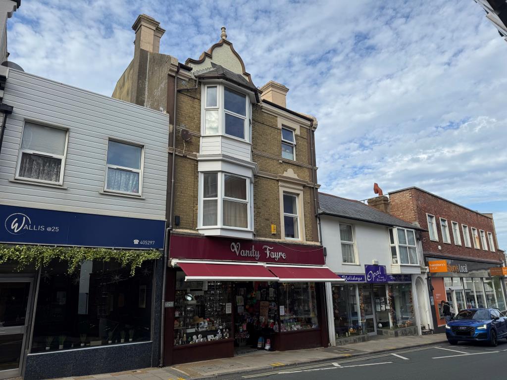 Lot: 94 - DOUBLE-FRONTED HIGH STREET SHOP WITH LARGE REAR STORES WITH POTENTIAL AND FREEHOLD INTEREST IN TWO FLATS OVER - View from the street